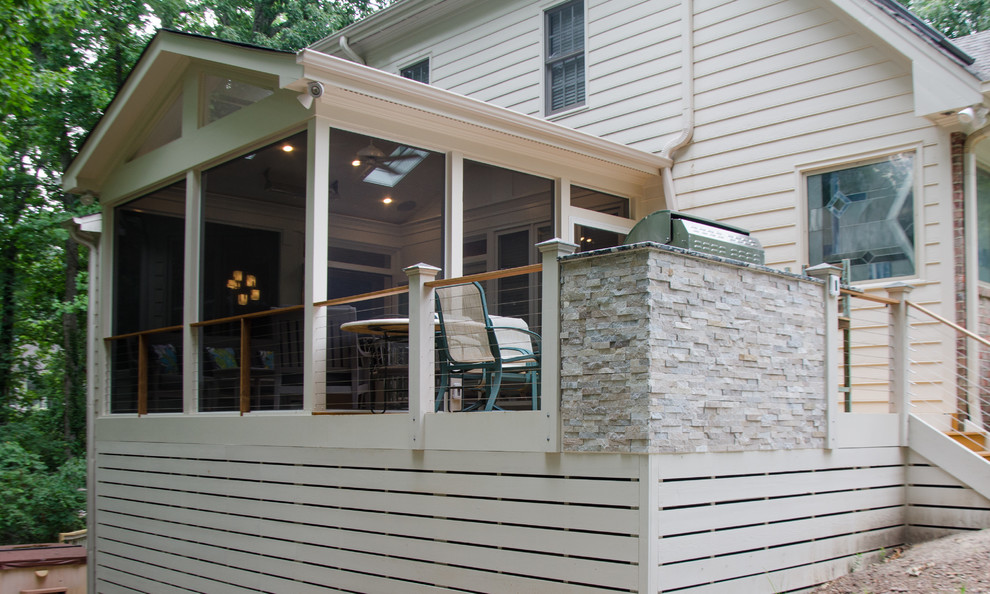 This is an example of a medium sized traditional back screened veranda in Raleigh with a roof extension.
