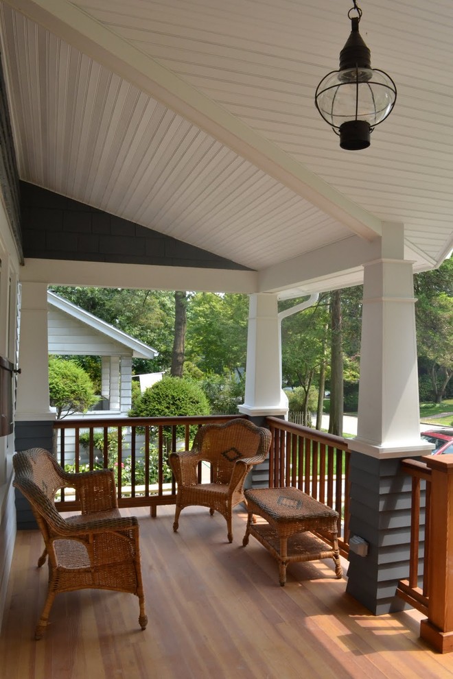 Cette photo montre un porche d'entrée de maison avant craftsman de taille moyenne avec une terrasse en bois et une extension de toiture.