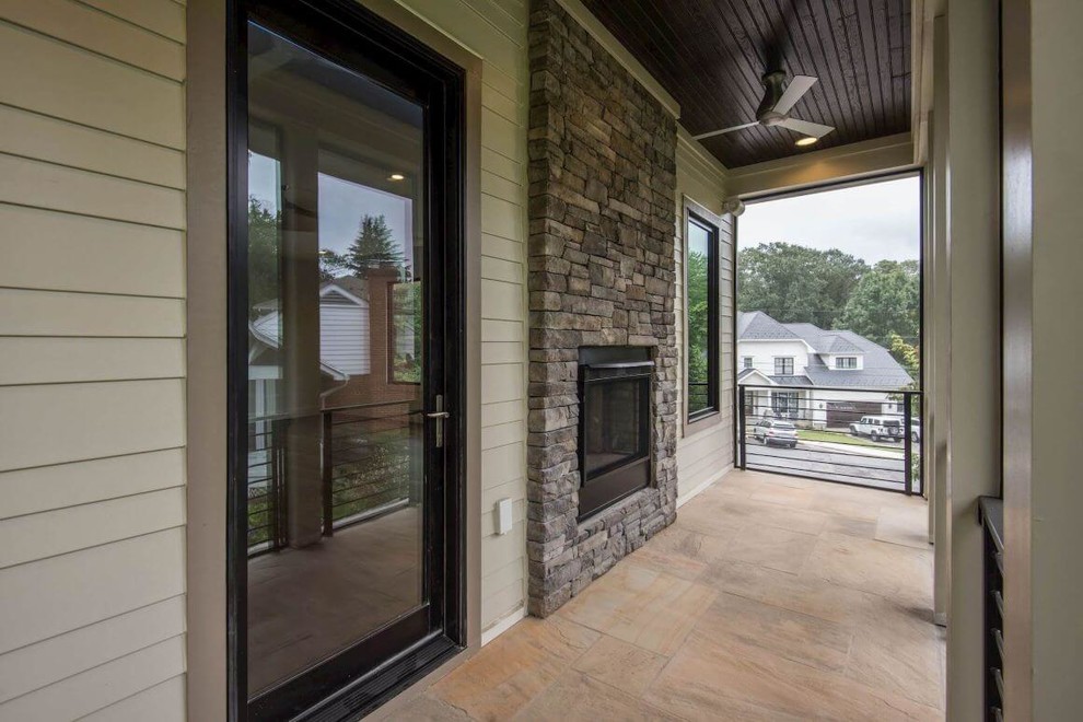 Immagine di un piccolo portico design nel cortile laterale con un caminetto, pavimentazioni in pietra naturale e un tetto a sbalzo