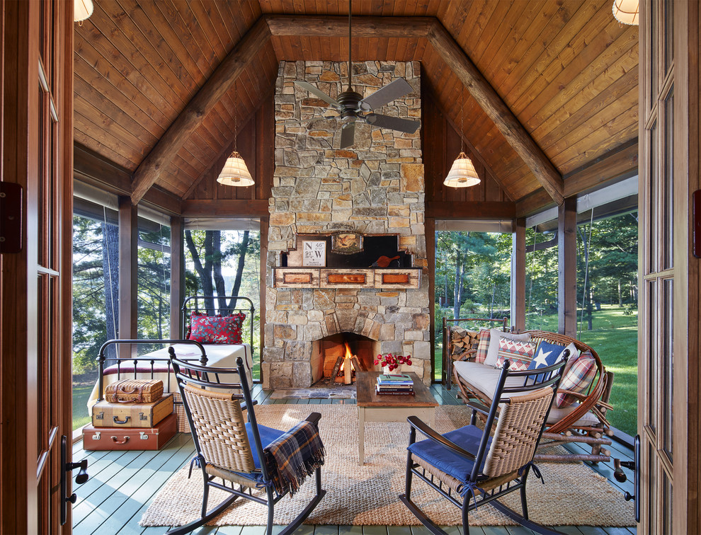 Cette image montre un porche d'entrée de maison chalet avec une moustiquaire, une terrasse en bois et une extension de toiture.