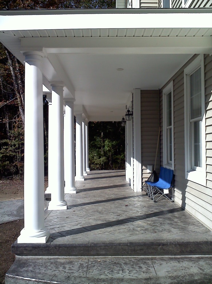 Classic front veranda in Bridgeport with stamped concrete and a roof extension.