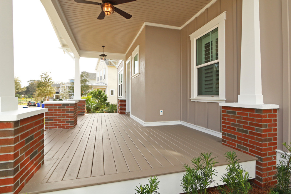 Cette image montre un porche d'entrée de maison avant craftsman de taille moyenne avec une terrasse en bois et une extension de toiture.