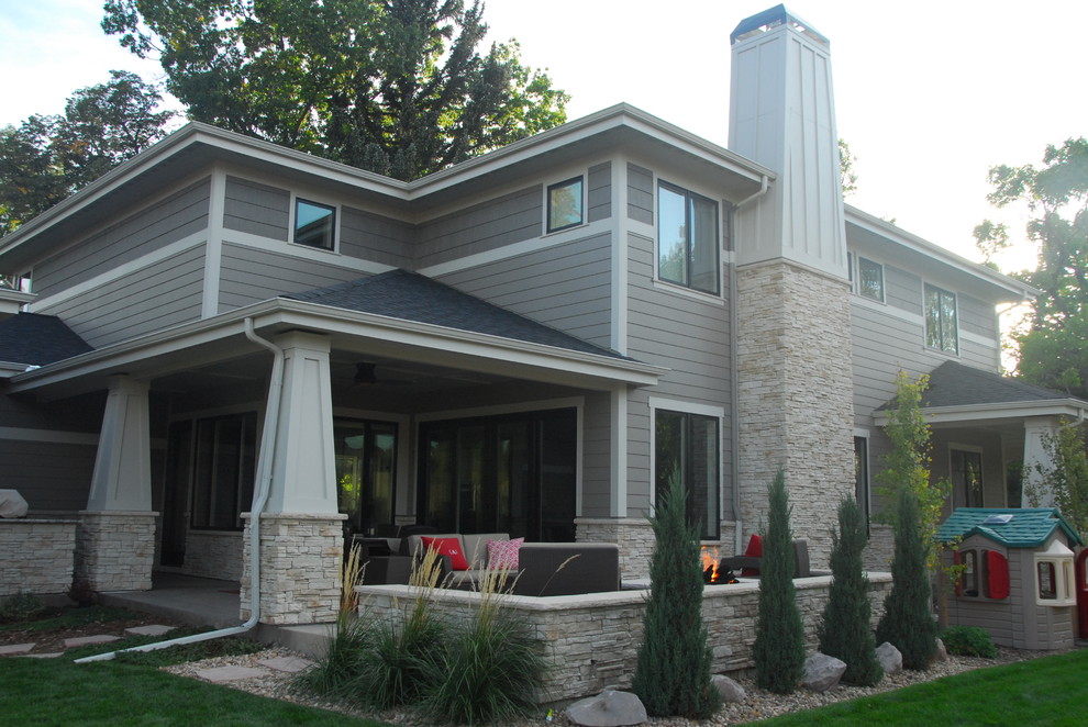 Esempio di un portico american style di medie dimensioni e dietro casa con un focolare e un tetto a sbalzo