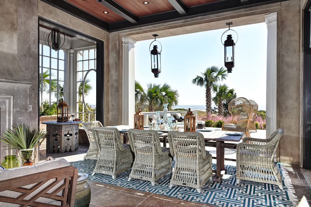 This is an example of a beach style veranda in Charleston with a roof extension and feature lighting.