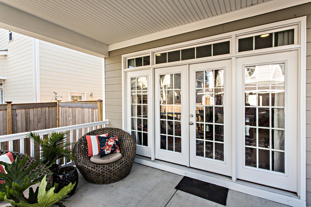 Cette image montre un porche d'entrée de maison arrière marin de taille moyenne avec une dalle de béton et une extension de toiture.