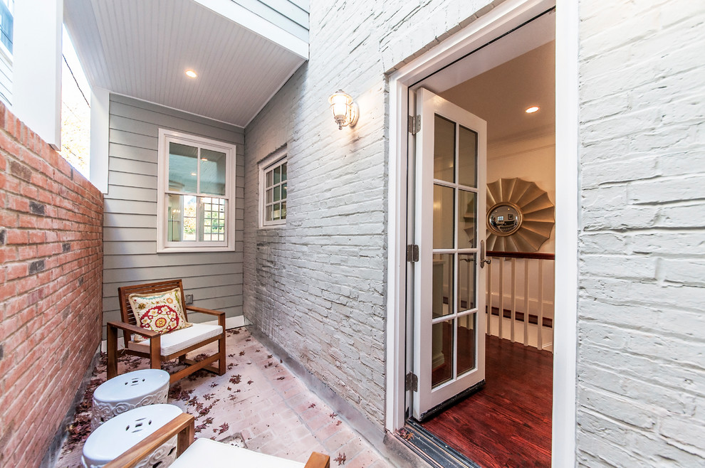 Transitional brick porch photo in San Francisco with a roof extension