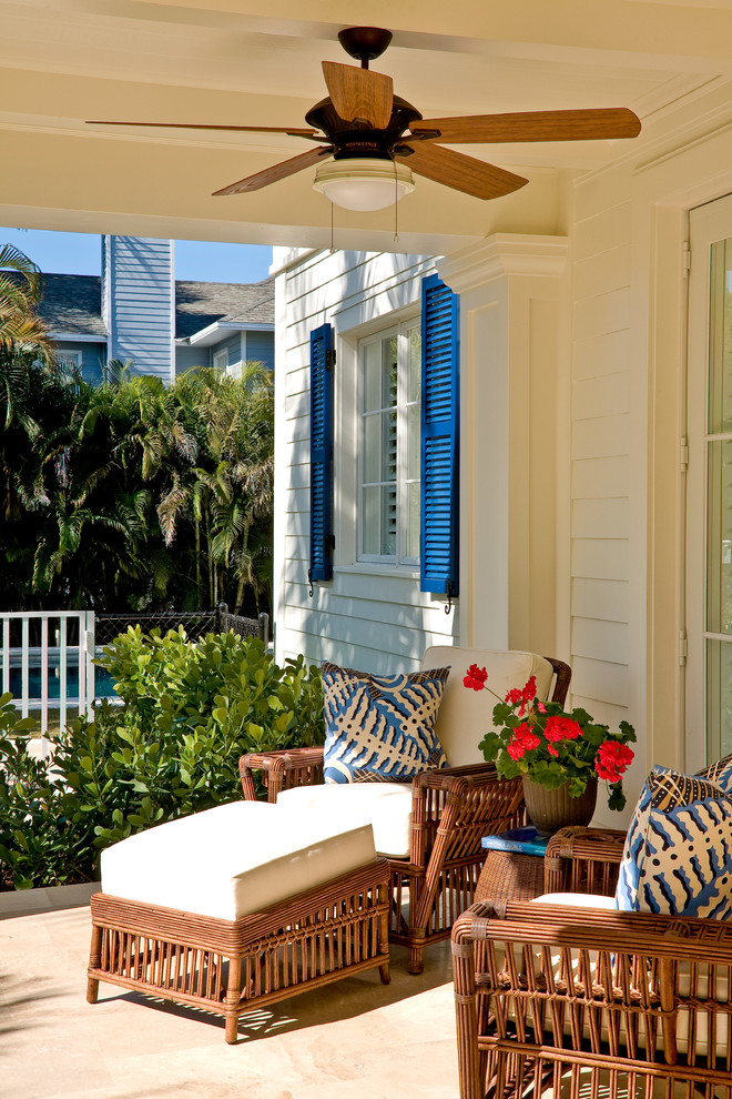 This is an example of a mid-sized tropical front porch design in Miami.