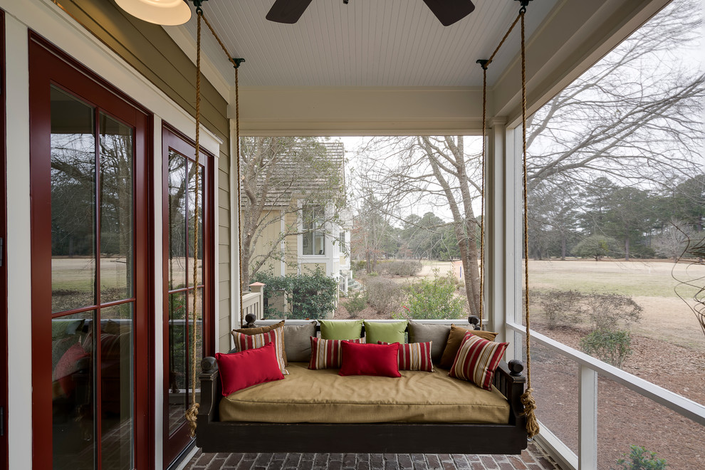 This is an example of a modern brick front porch design in Atlanta with a roof extension.
