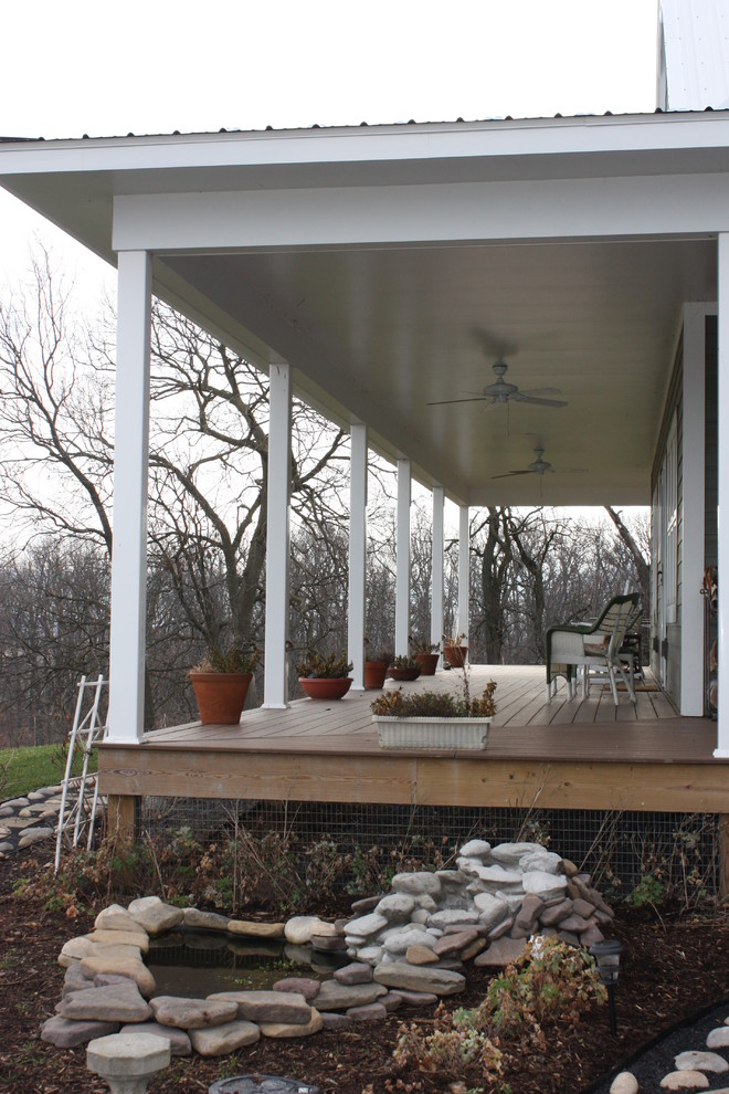 Inspiration pour un grand porche d'entrée de maison latéral rustique avec un point d'eau, une terrasse en bois et une extension de toiture.