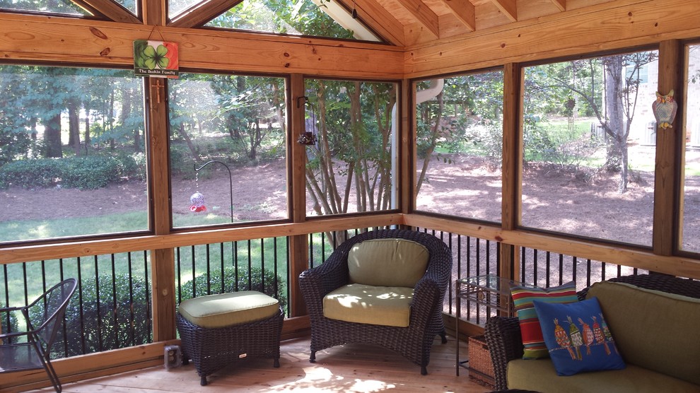 Cette photo montre un grand porche d'entrée de maison arrière chic avec une moustiquaire et une extension de toiture.