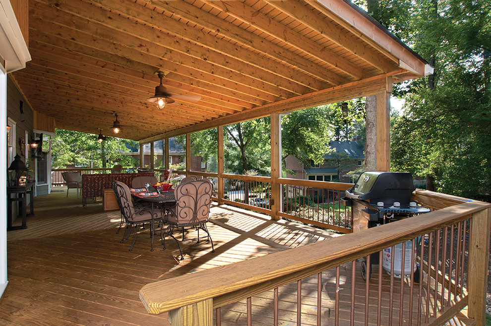 Cette photo montre un très grand porche d'entrée de maison arrière chic avec une extension de toiture.