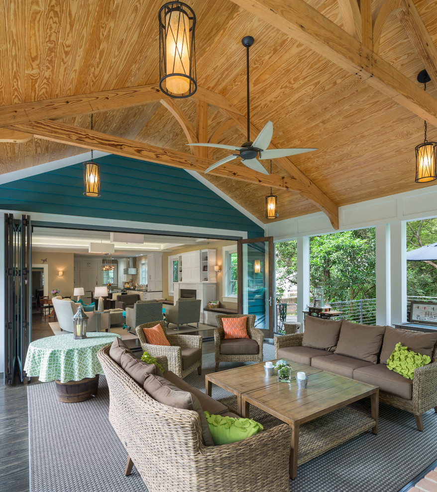Idée de décoration pour un grand porche d'entrée de maison arrière chalet avec une extension de toiture, un foyer extérieur et une terrasse en bois.