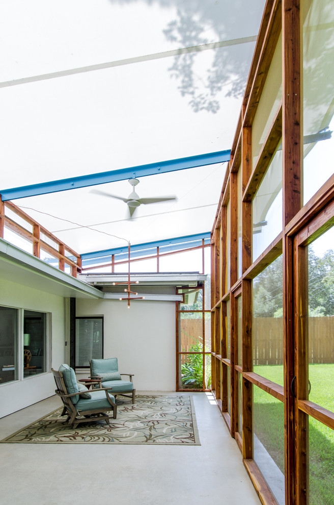 Idée de décoration pour un porche d'entrée de maison design avec une extension de toiture.