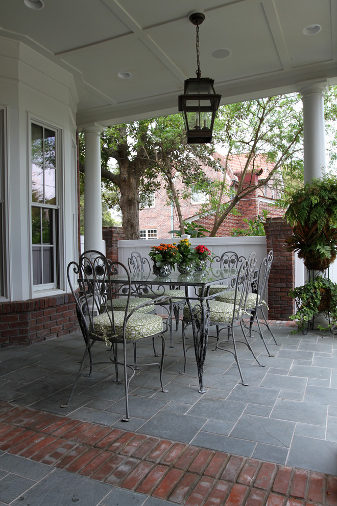 Inspiration for a medium sized traditional back veranda in Jacksonville with natural stone paving, a roof extension and a potted garden.