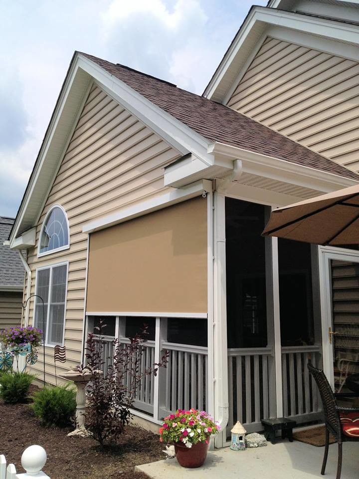 Cette image montre un porche d'entrée de maison latéral avec une moustiquaire, une dalle de béton et un auvent.