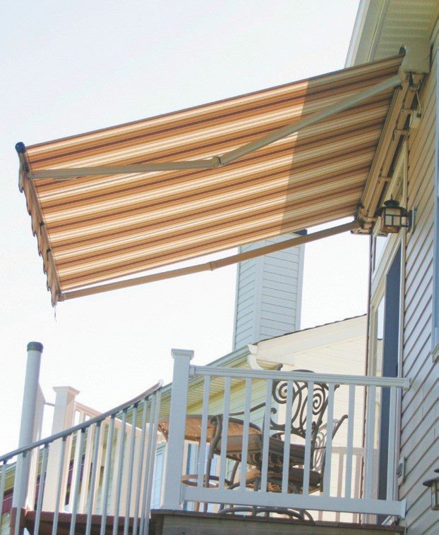 Modelo de terraza en patio delantero con adoquines de ladrillo y toldo