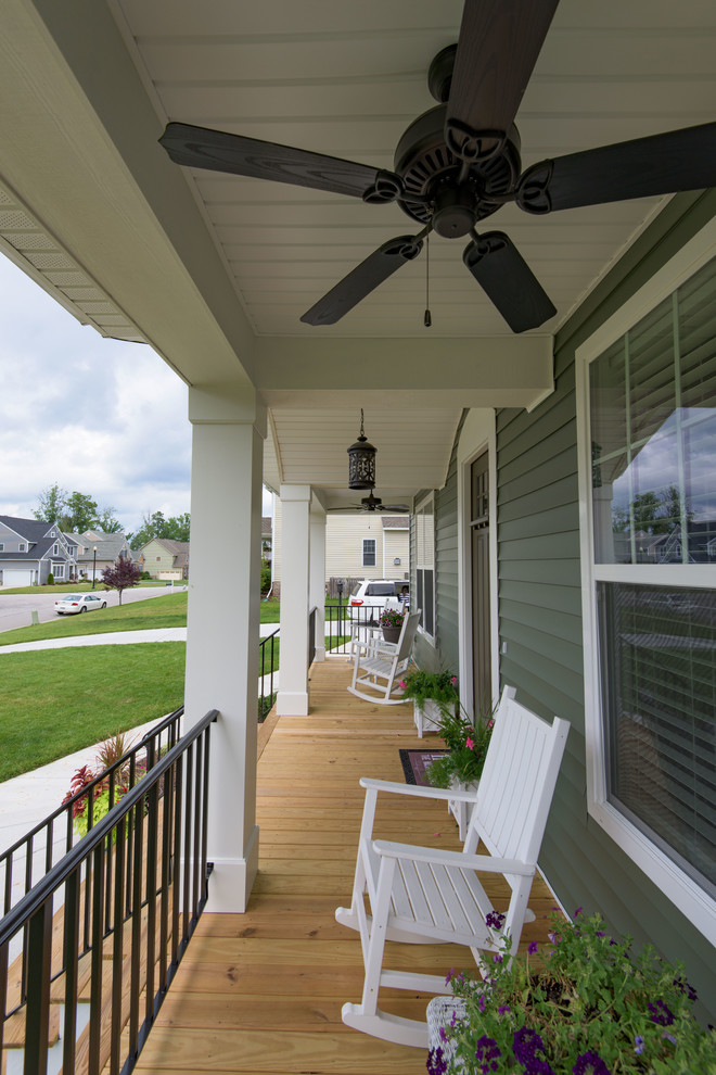 Cette photo montre un porche d'entrée de maison avant craftsman avec une terrasse en bois et une extension de toiture.