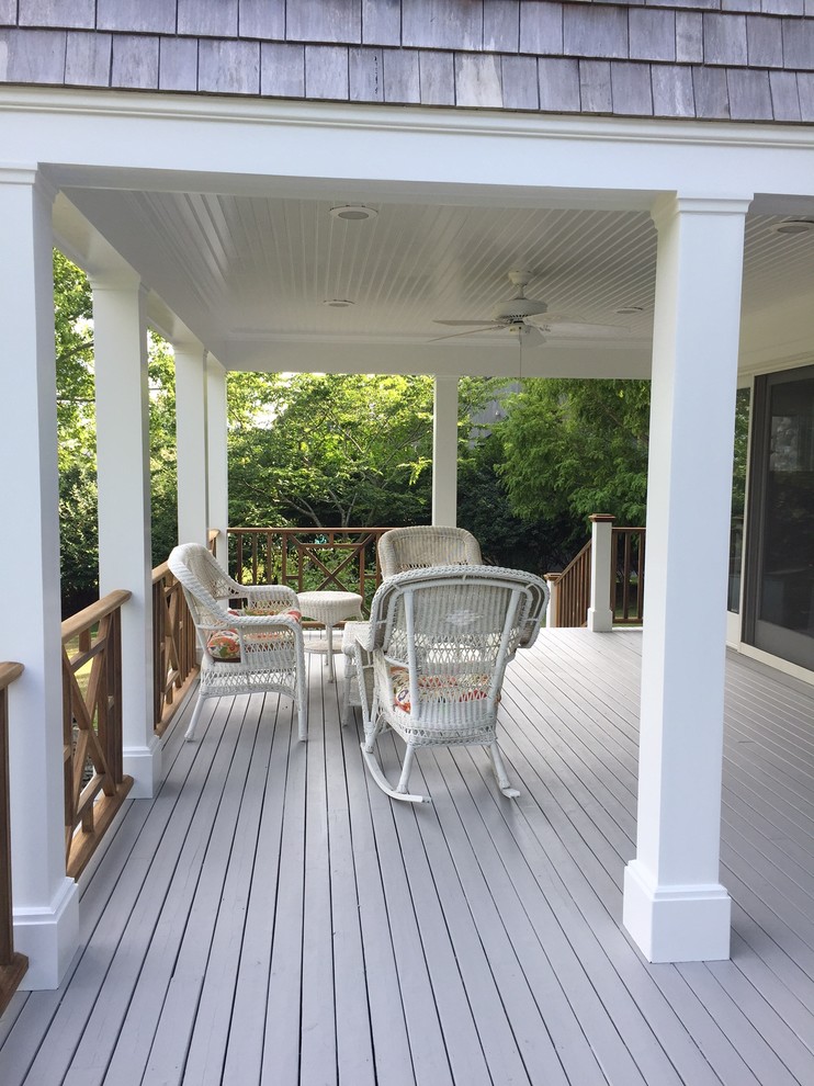 This is an example of a mid-sized traditional back porch design in New York with decking and a roof extension.