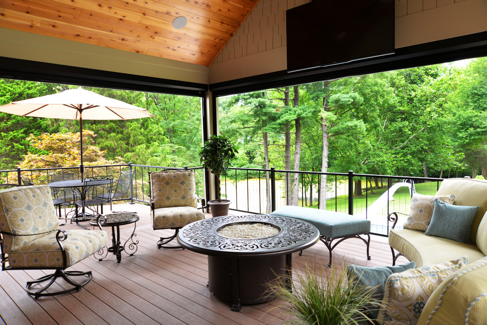 This is an example of a large traditional screened-in back porch design in Louisville with decking and a roof extension.