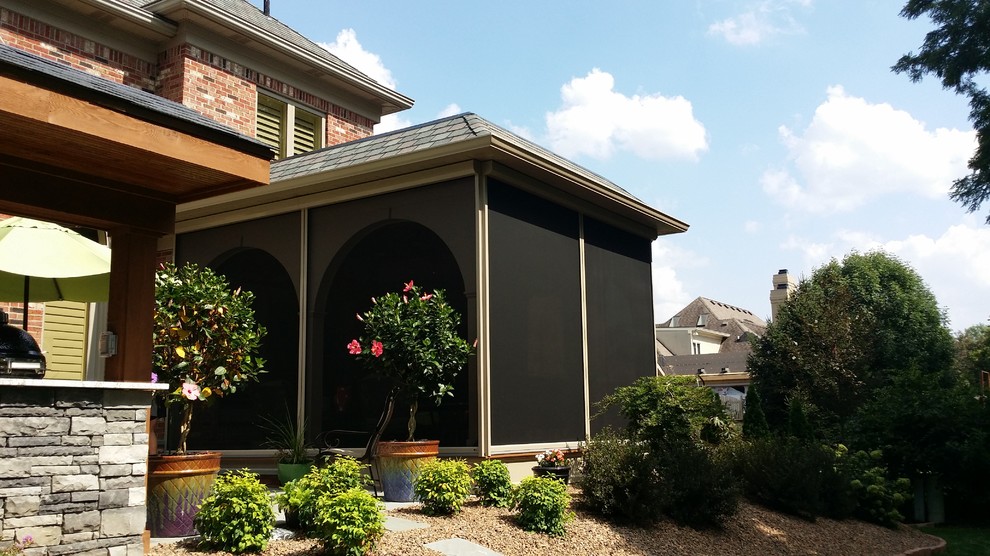 Idées déco pour un grand porche d'entrée de maison arrière classique avec une extension de toiture, une terrasse en bois et une moustiquaire.