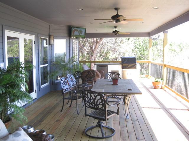 Cette image montre un porche d'entrée de maison arrière traditionnel avec une terrasse en bois et une extension de toiture.