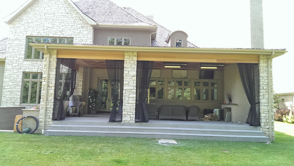 На фото: большая веранда на заднем дворе в стиле кантри с летней кухней, настилом и навесом