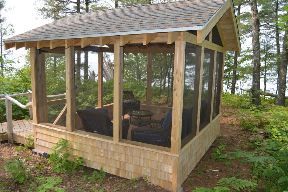 Aménagement d'un porche d'entrée de maison avant craftsman de taille moyenne avec une moustiquaire et une terrasse en bois.