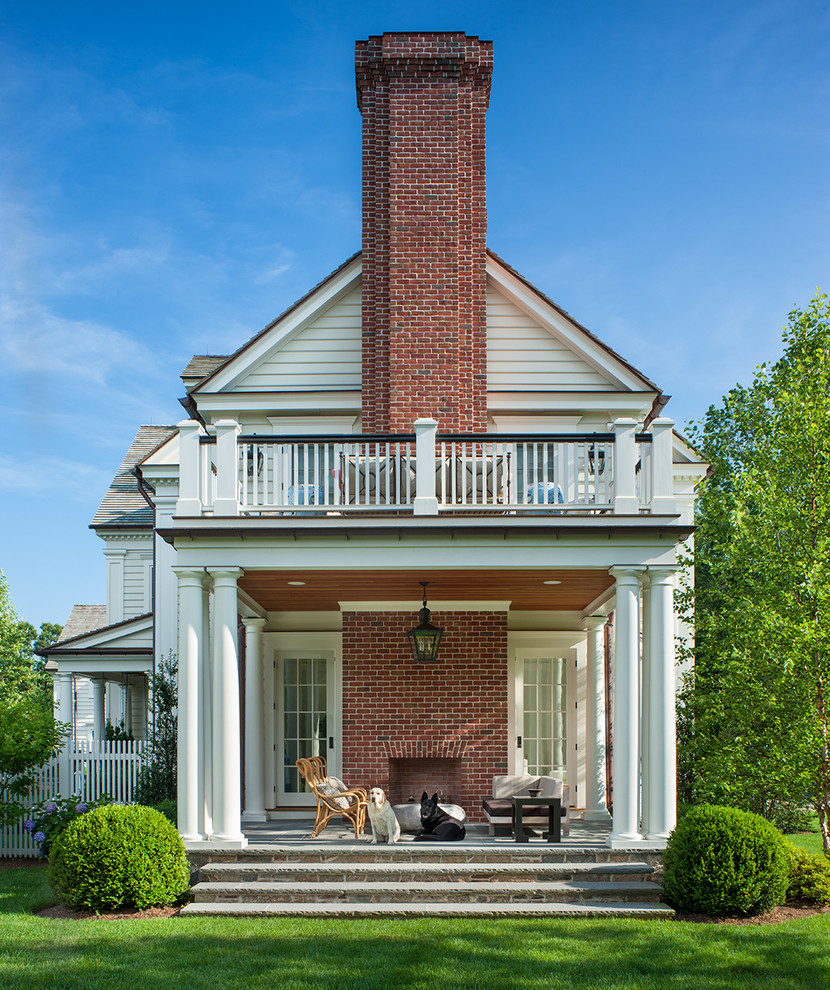 Aménagement d'un porche d'entrée de maison classique de taille moyenne avec un foyer extérieur et une extension de toiture.