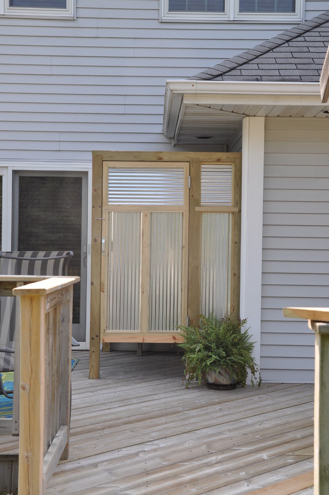 Exempel på en stor eklektisk veranda på baksidan av huset, med trädäck och en pergola