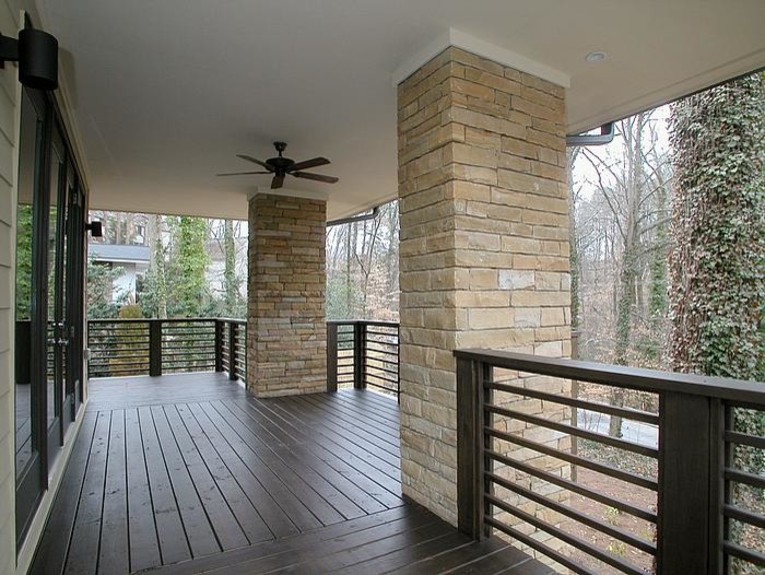 Inspiration pour un très grand porche d'entrée de maison arrière minimaliste avec une terrasse en bois et une extension de toiture.