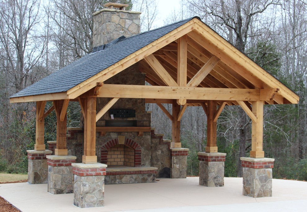 Aménagement d'un porche d'entrée de maison arrière montagne de taille moyenne avec un foyer extérieur, une pergola et une dalle de béton.