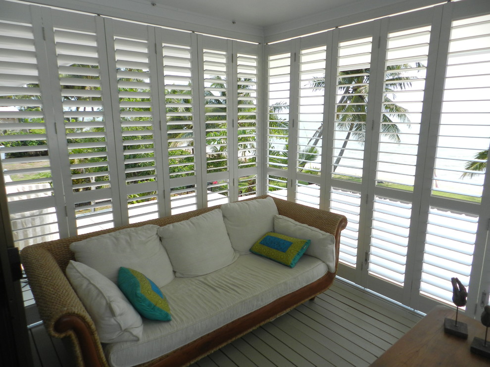Foto di un piccolo portico tropicale dietro casa con pedane, un tetto a sbalzo e un portico chiuso