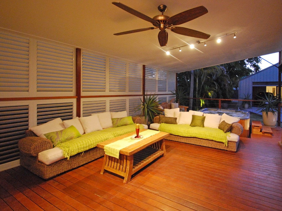 Imagen de terraza tropical en patio trasero y anexo de casas con entablado