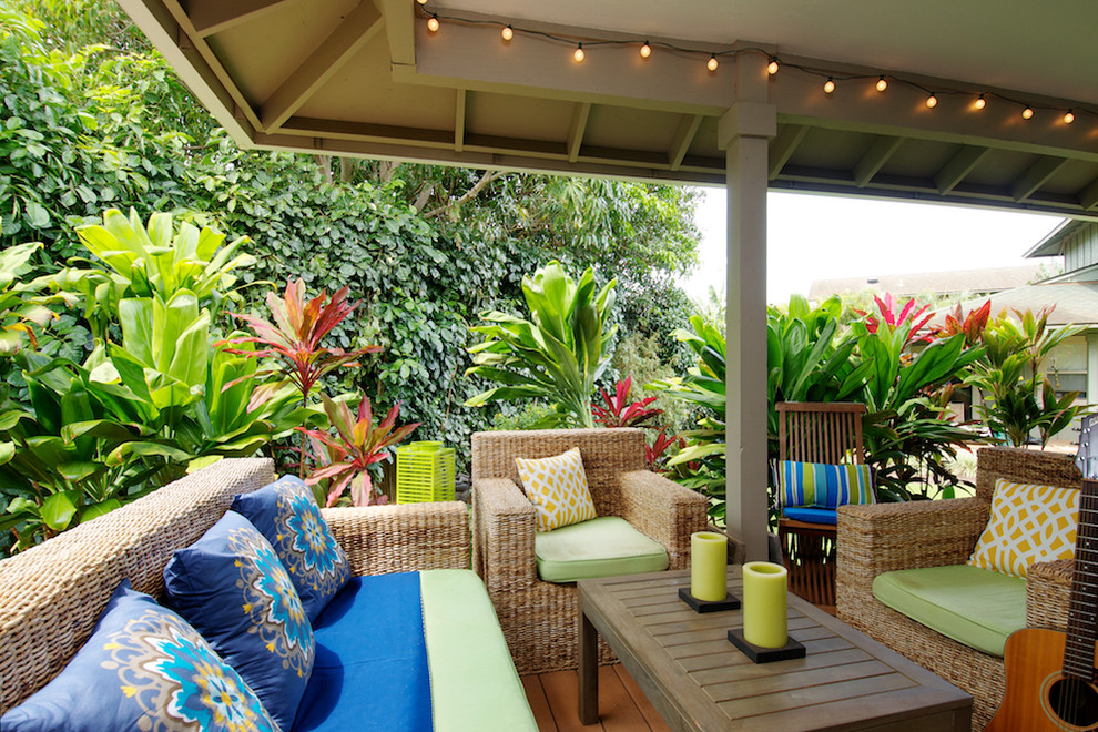 Inspiration för en stor tropisk veranda längs med huset, med trädäck och takförlängning