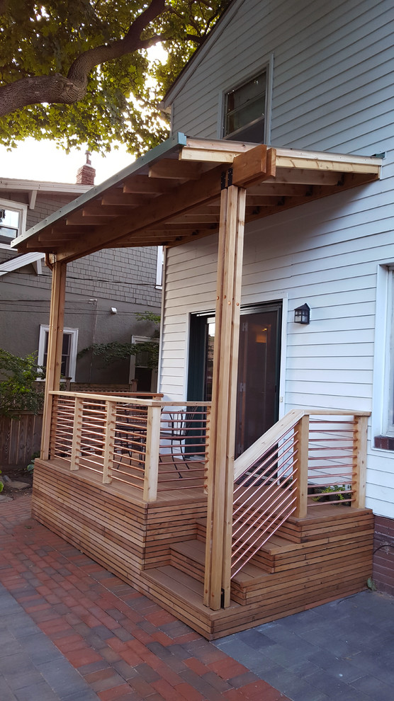 This is an example of a large traditional back porch design in Minneapolis with decking and a roof extension.
