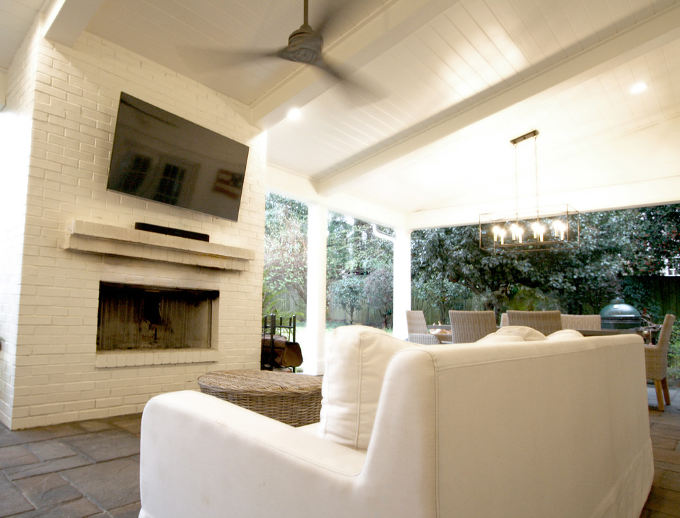 This is an example of a mid-sized transitional stone back porch design in Atlanta with a fireplace and a roof extension.