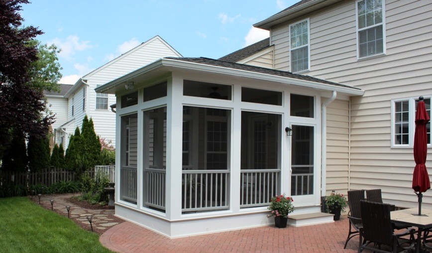 Photo of a small classic back screened veranda in DC Metro with brick paving and a roof extension.
