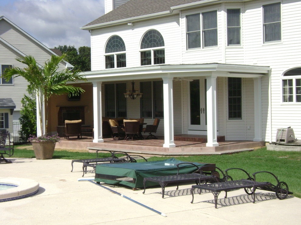 Ejemplo de terraza clásica de tamaño medio en patio trasero y anexo de casas con brasero y adoquines de piedra natural