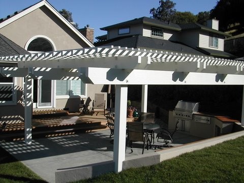 Exemple d'un porche d'entrée de maison arrière chic avec une cuisine d'été, une dalle de béton et une pergola.