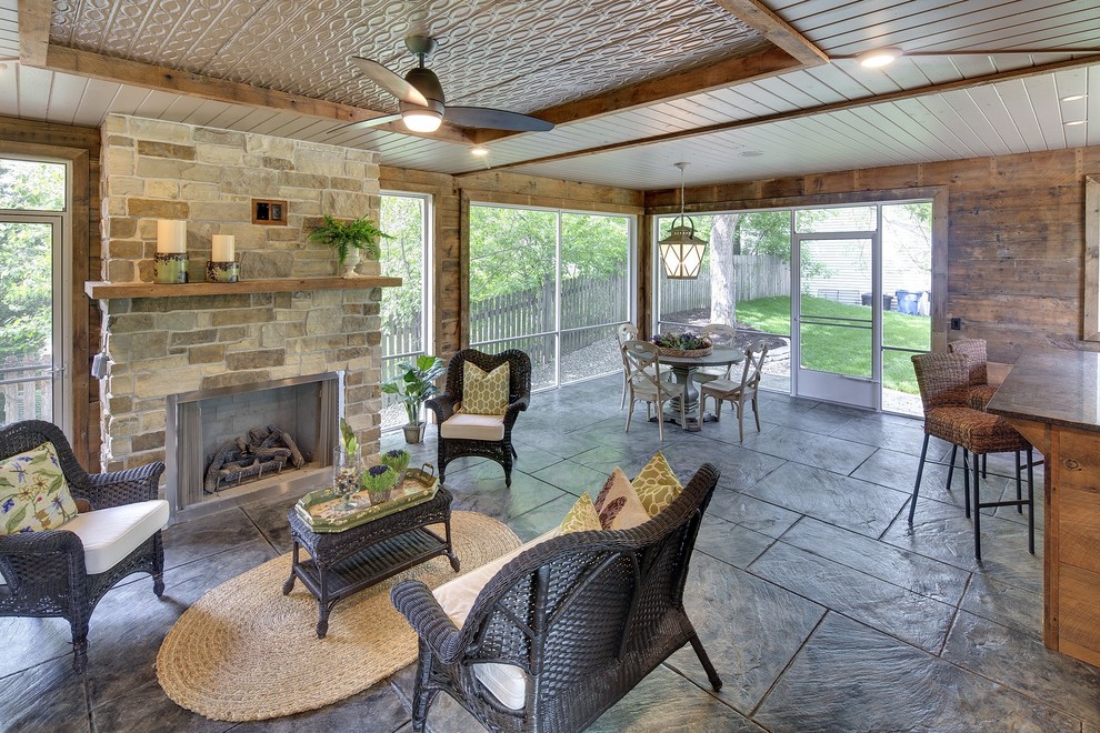 This is an example of a large classic back screened veranda in Minneapolis with stamped concrete and a roof extension.