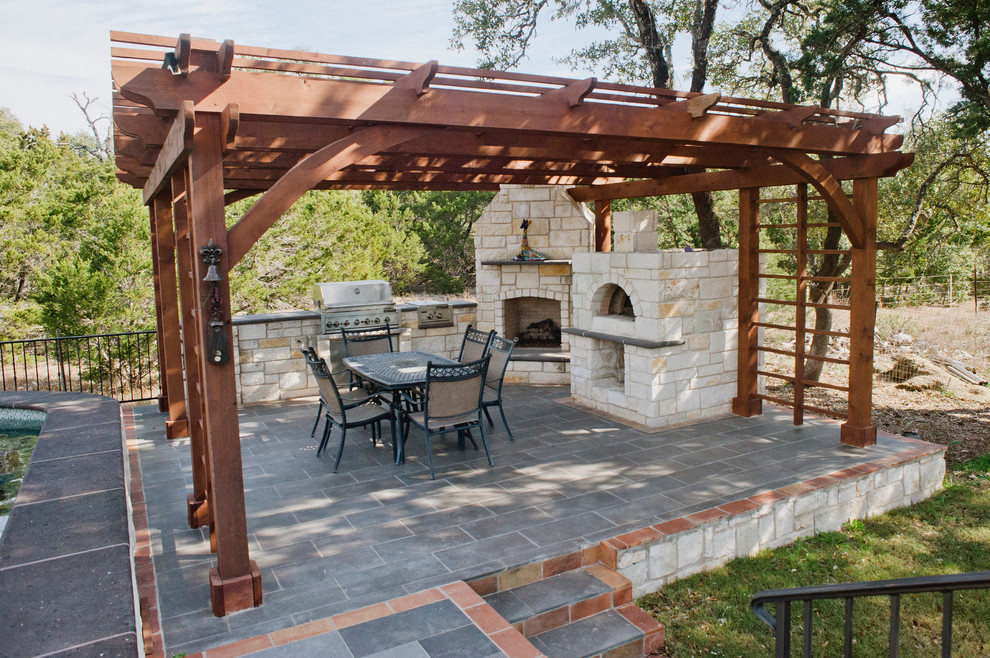 This is an example of an expansive rustic back patio in Austin with tiled flooring, a pergola and a bbq area.