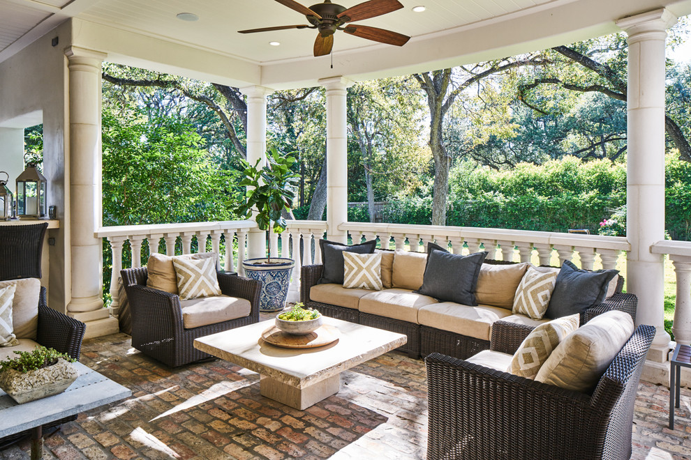 This is an example of a traditional back veranda in Austin with a roof extension and brick paving.