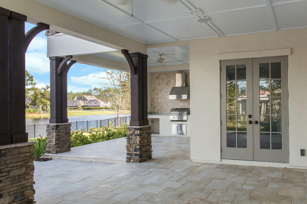 Imagen de terraza extra grande en patio trasero y anexo de casas con cocina exterior y adoquines de piedra natural