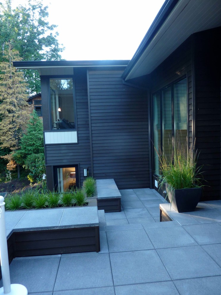Große Moderne Veranda hinter dem Haus mit Feuerstelle und Betonboden in Portland
