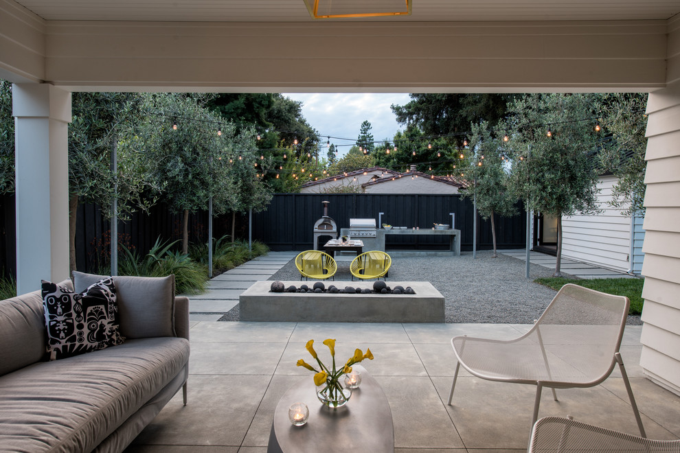 Foto di un patio o portico design dietro casa con lastre di cemento e un tetto a sbalzo
