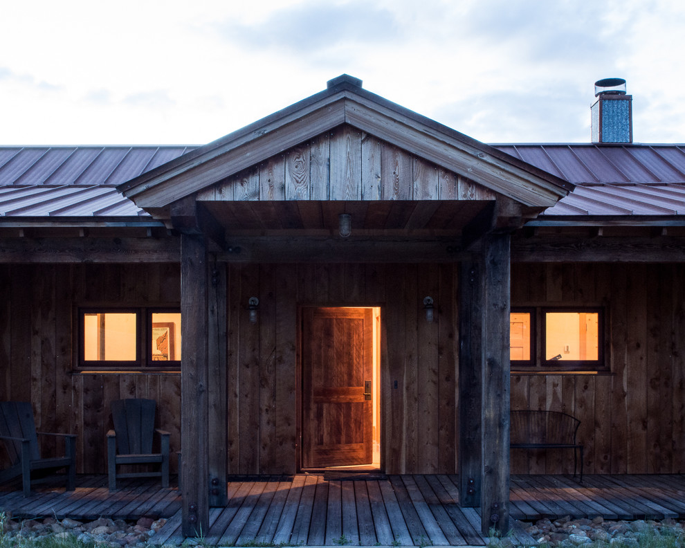 Exemple d'un porche d'entrée de maison avant montagne de taille moyenne avec une terrasse en bois et une extension de toiture.