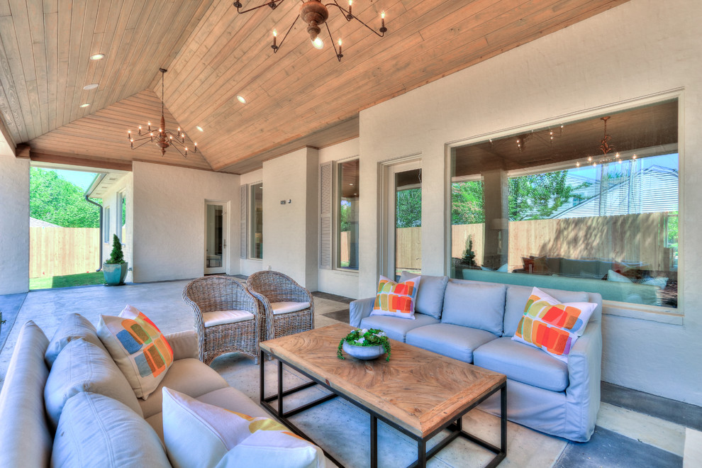 Inspiration pour un grand porche d'entrée de maison arrière traditionnel avec du béton estampé et une extension de toiture.