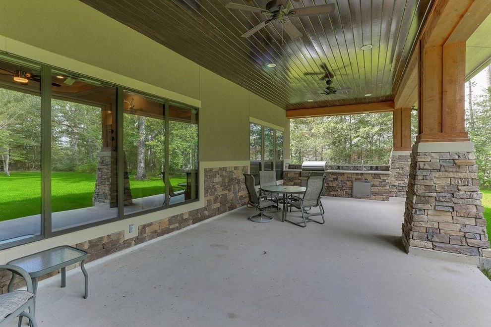 Пример оригинального дизайна: веранда среднего размера на заднем дворе в стиле кантри с летней кухней, покрытием из бетонных плит и навесом