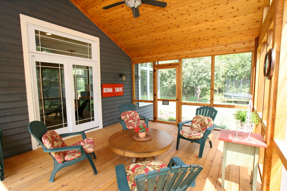This is an example of a large traditional side screened veranda in Minneapolis with decking and a roof extension.