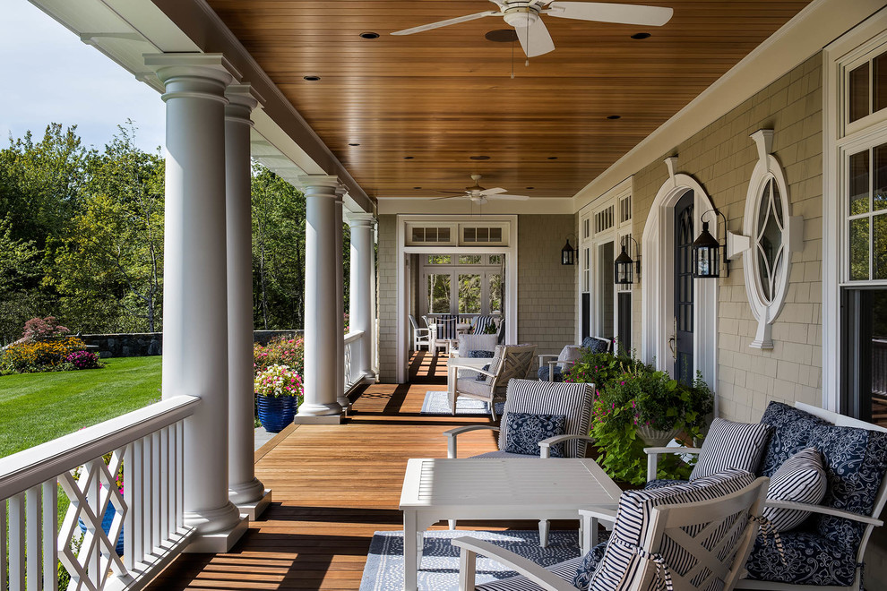 Idée de décoration pour un porche d'entrée de maison tradition avec une terrasse en bois et une extension de toiture.